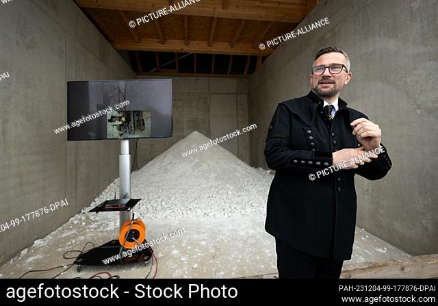 04 December 2023, Saxony, Diera-Zehren: Martin Dulig (SPD), Saxony's Minister of Economic Affairs, stands in front of a pile of kaolin at the opening of the new...
