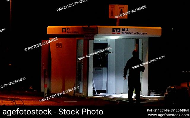 31 December 2021, Rhineland-Palatinate, Mainz-Mombach: A man stands in front of a free-standing ATM in Mainz-Mombach, which was blown up by unknown persons...