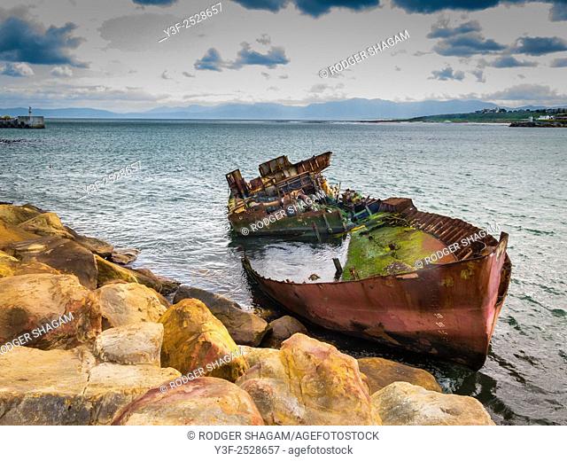 A boat run aground and stripped of all recoverable fixtures and fittings. Gaansbaai Goose Bay, Western Cape Province, South Africa.