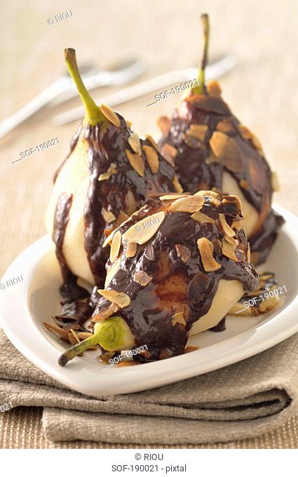 Stewed pears with chocolate sauce and thinly sliced almonds