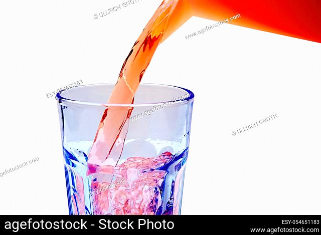 A fresh juicy beverage is being poured into a glass