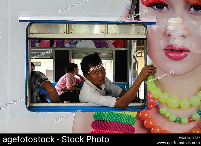Yangon, Republic of the Union of Myanmar, Asia - A man looks out the window of a waiting local train of the Circle Line at the central railway station