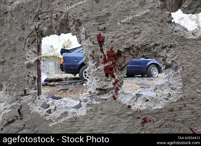 RUSSIA, DONETSK - OCTOBER 20, 2023: A destroyed car is seen through a hole in a bloodstained wall after a military strike by the Armed Forces of Ukraine on...