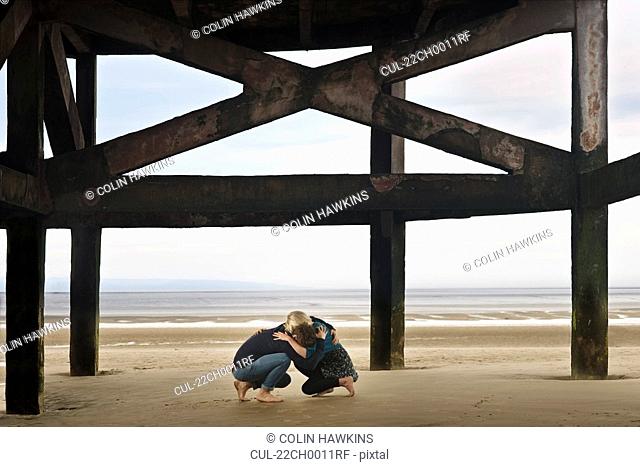 Couple sheltering on beach