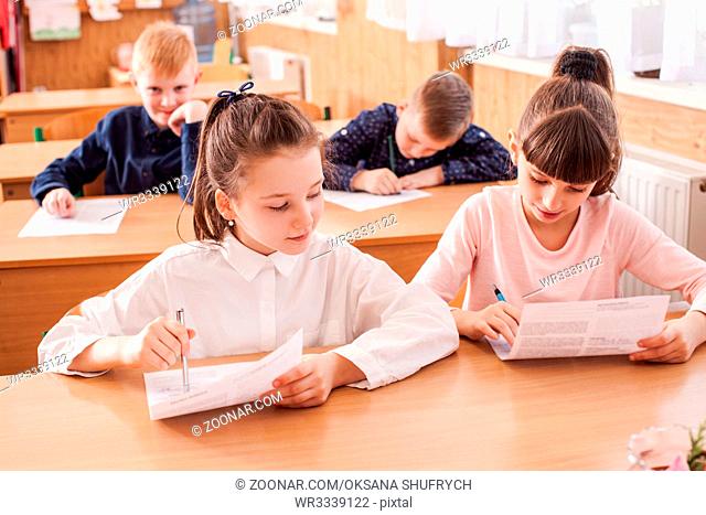 Children of primary school taking an exam writing school test