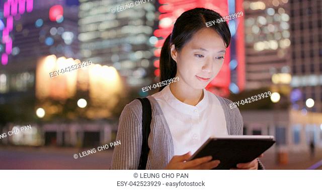 Business woman use of tablet computer at night in the outdoor station