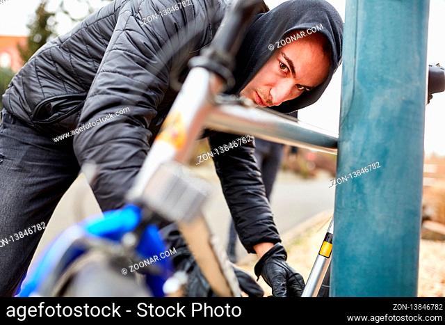 Jugendlicher schließt sein Fahrrad in der Stadt ab