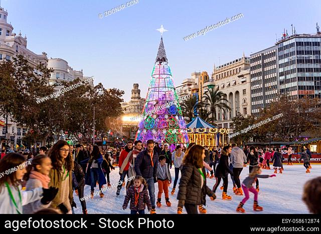 Valencia, Spain - Dec 16, 2017: People ice skating on Christmas ice skating ring on christmas fair on Modernisme plaza of the city hall on 16th of December