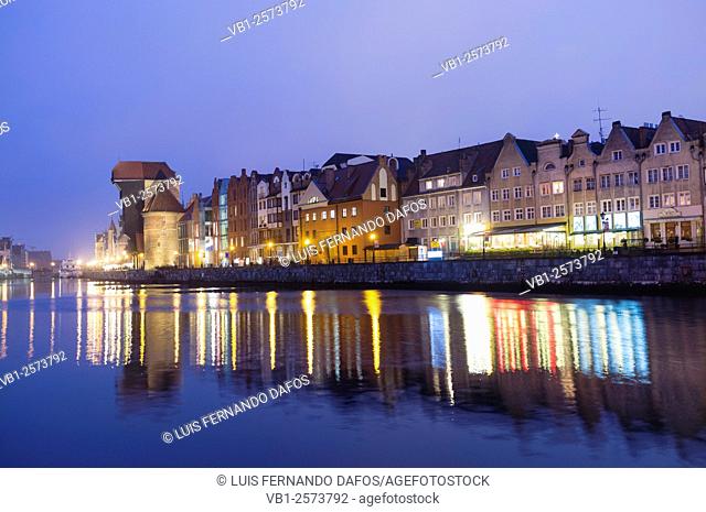Waterfront tenements and crane reflected on Motlawa river at dusk. Gdansk, Poland