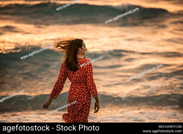 Woman at the seafront at sunrise, Miami, Florida, USA