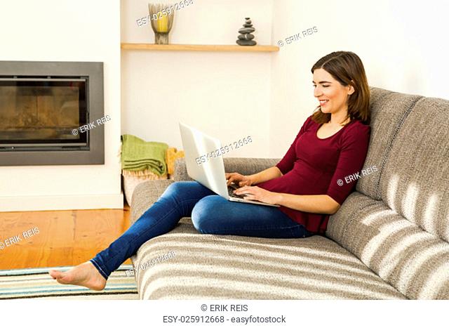 Beautiful woman sitting on the floor working on the laptop