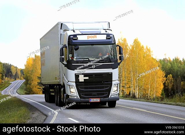 White Volvo FH delivery truck of Posti Kuljetus Oy on highway 52 at autumn dusk. Salo, Finland. October 11, 2019