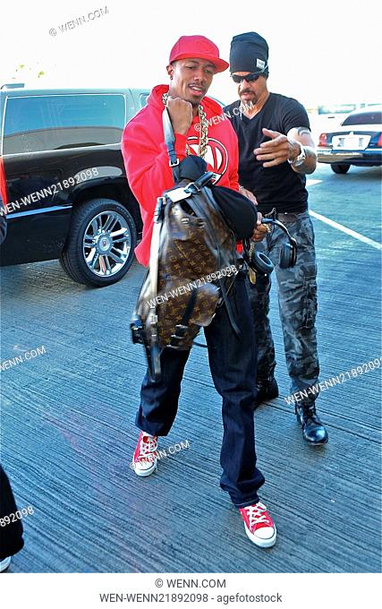 Nick Cannon departs from Los Angeles International Airport (LAX) wearing his N'Credible red hoodie and laden with gold chain necklaces