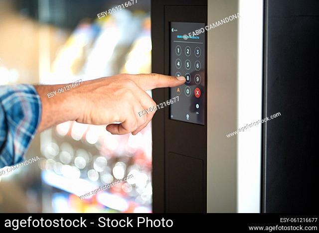 Close up of man hand typing number code on touch screen display - concept of security password and automatic distributor food - caucasian male finger type 8