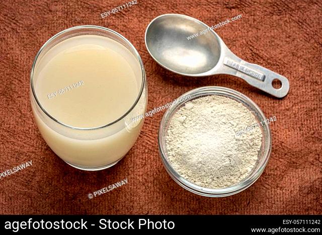 food grade diatomaceous earth supplement - powder and in a glass of water with measuring scoop
