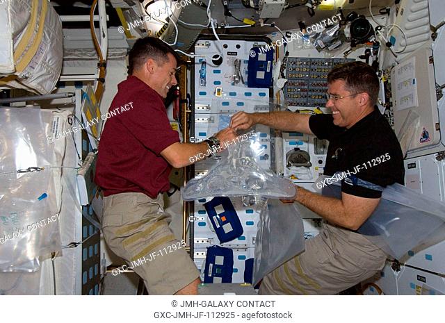 Astronauts Shane Kimbrough (left) and Steve Bowen, both STS-126 mission specialists, work on the middeck of Space Shuttle Endeavour during flight day three...