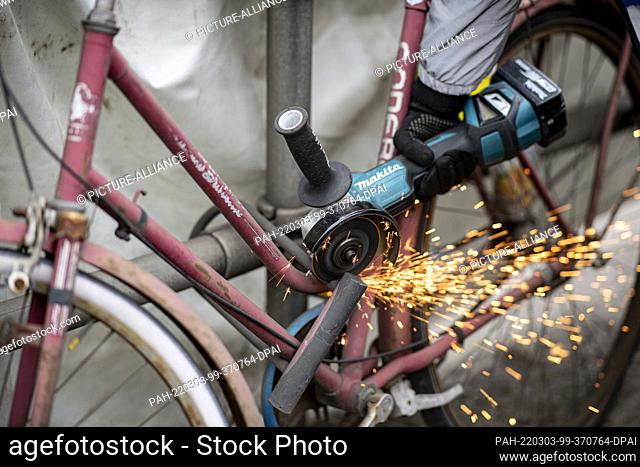 03 March 2022, Berlin: An employee of the Mitte district office removes a scrap bicycle at the Wedding S-Bahn and U-Bahn station