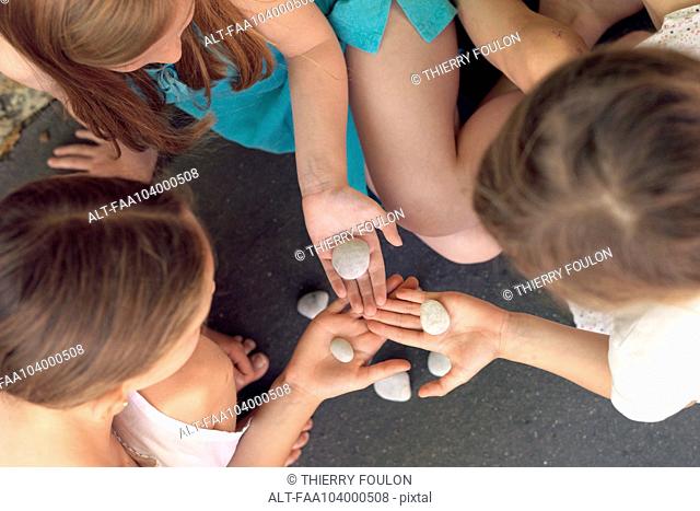 Girls studying rocks together, overhead view