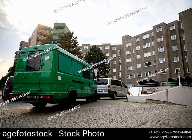 15 July 2020, Berlin: Police vehicles are parked in front of a building in the Berlin-Gesundbrunnen district. The Berlin police have launched a large-scale raid...