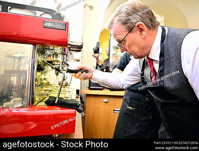 11 October 2023, Thuringia, Weimar: Bodo Ramelow (Die Linke), Minister President of Thuringia, tries his hand at the coffee machine at the Samocca Café in...