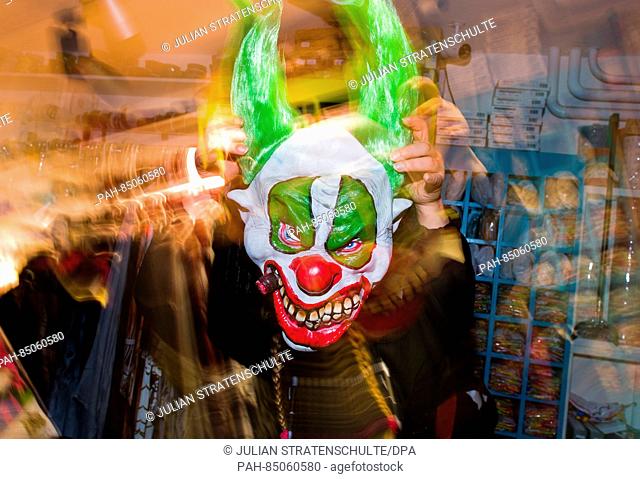 A salesperson shows off a clown mask at 'Lutzmann Berger & Traupe, ' a specialty store for costumes and theatrical supplies in Hanover, Germany, 25 October 2016