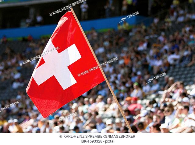 Swiss fan waving the national flag at a sports event