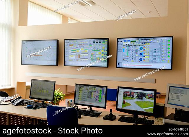water treatment facility plant factory control room with many computer monitors panels and other maintain equipment