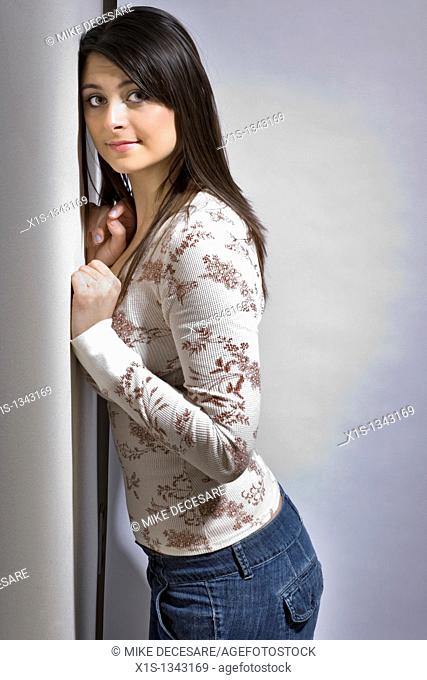 Long haired girl leans against the wall