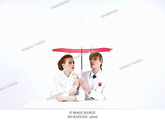 Businesspeople holding an umbrella