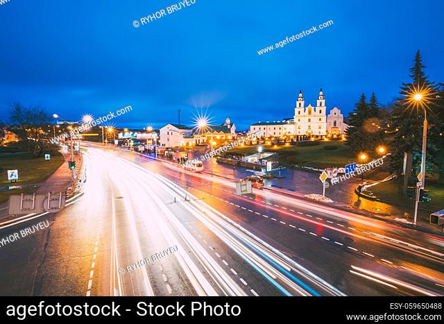 Minsk, Belarus. Night Traffic On Illuminated Street And Cathedral Of Holy Spirit In Minsk. Famous And Main Orthodox Church Of Belarus At Evening