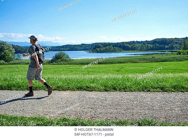 Deutschland, Bayern, Mann wandert am Ostersee