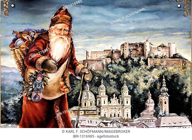 Santa Claus in front of a panoramic view of Salzburg, painted sign advertising a shop for Christmas decorations, Christmas, Judengasse lane, old town, Salzburg