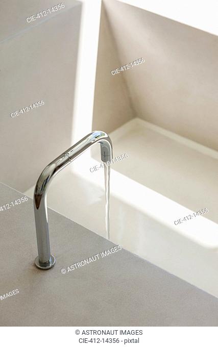 Modern faucet filling bathtub