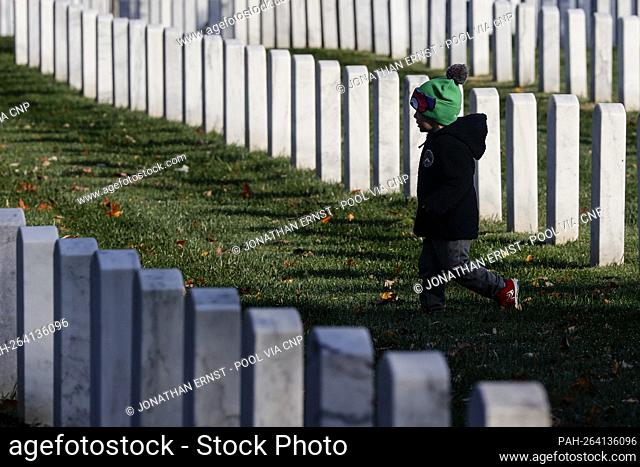 A child walks among graves on Veterans Day in Arlington National Cemetery in Arlington, Virginia, U.S., November 11, 2021