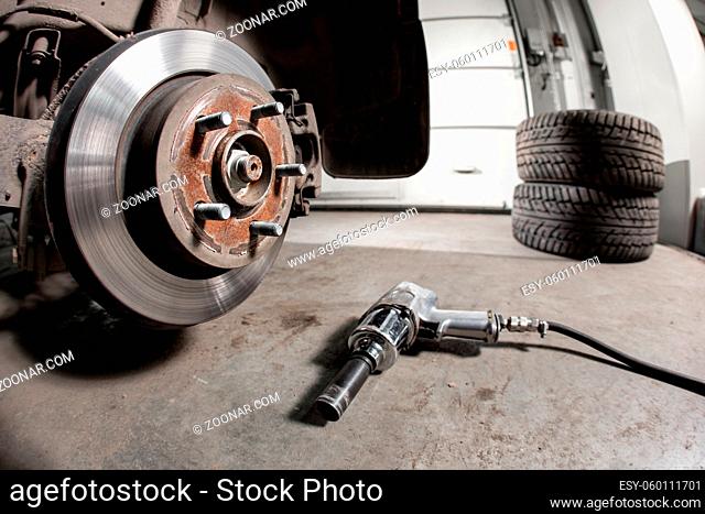 Closeup disc brake of the vehicle for repair. shot wheel, the tool for loosening the nuts. internal screw