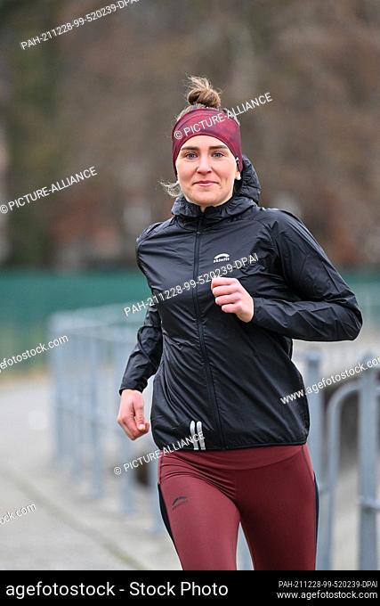 PRODUCTION - 16 December 2021, Baden-Wuerttemberg, Lindau Am Bodenseee: The athlete Valeria Kleiner jogs along the shore of Lake Constance
