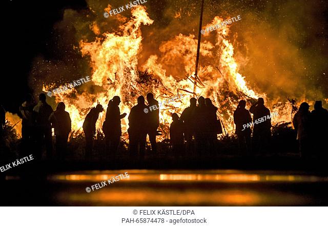 A group of people stand together in front of a bonfire in Eriskirch, Germany, 13 February 2016. The 49th Eriskirch bonfire is a traditional event which is made...