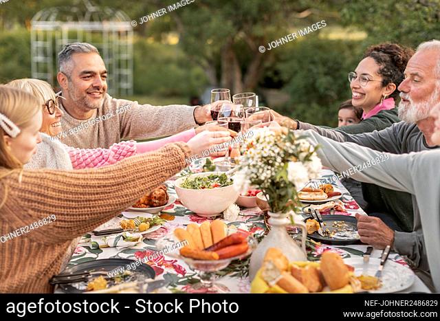 Family toasting during meal in garden
