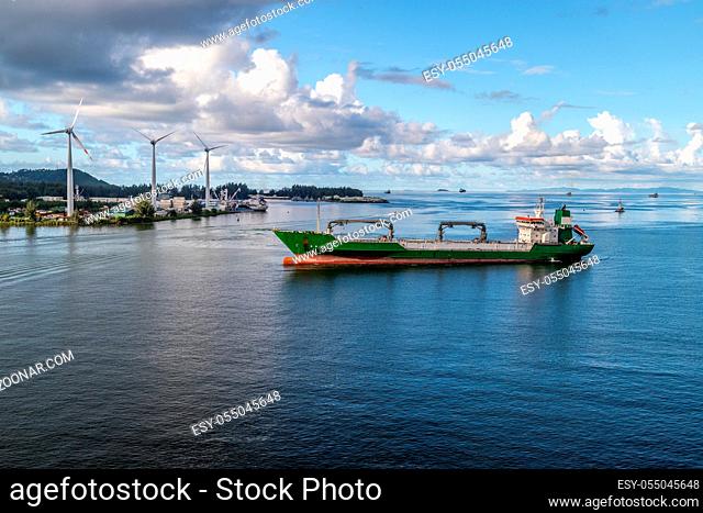 Port Victoria on Seychelles island mahé with cargo ship in front and wind wheels in the background