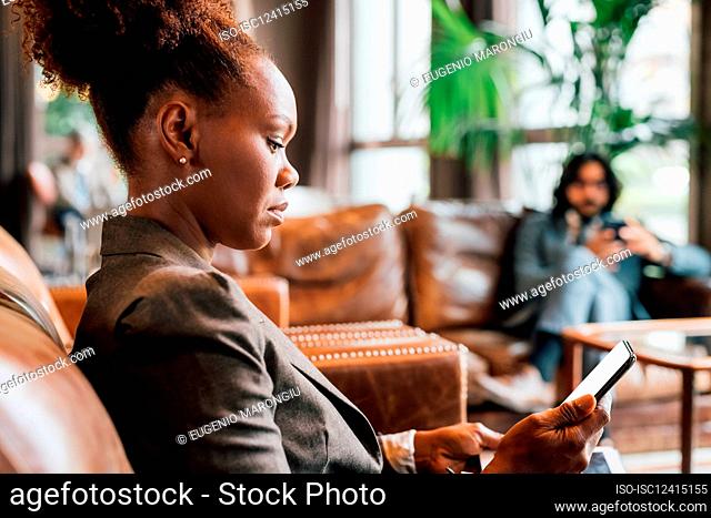 Italy, Profile of businesswoman with smart phone in creative studio