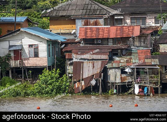 Malay houses by the Sarawak river, Kuching, East Malaysia, Borne. Malay houses by the Sarawak River in Kuching are traditional wooden stilt houses built and...