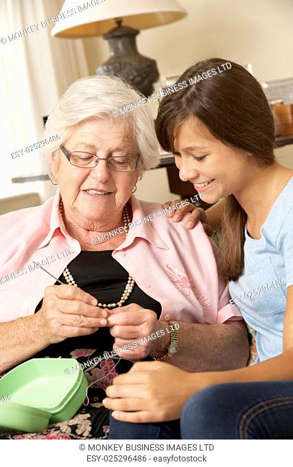 Grandmother Showing Granddaughter How To Crochet At Home