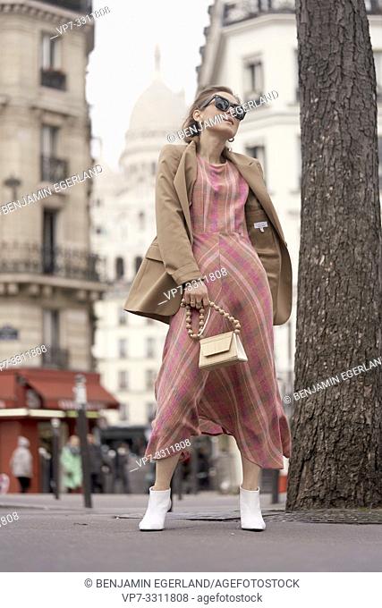 fashionable blogger woman at street during fashion week, in front of touristic sight Basilica Sacré-Cœur, in city Paris, France