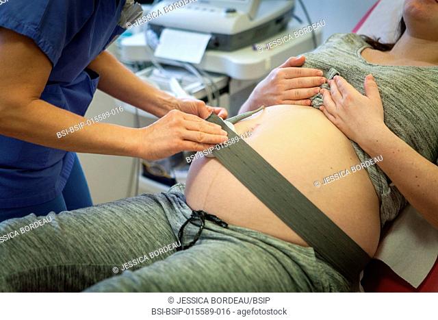 Reportage in the maternity, gynecology and obstectrics emergency service in the Métropole Hospital, Chambéry, France. A midwife carries out foetal monitoring on...