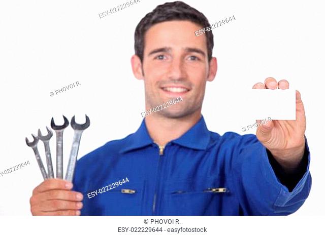 Mechanic holding selection of spanners and business card