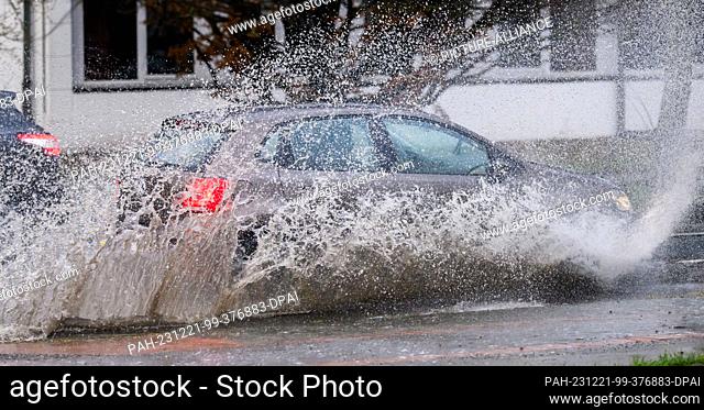 21 December 2023, Lower Saxony, Hanover: A car drives over a flooded road in heavy rain. Storm ""Zoltan"" passes over Germany with gale-force winds