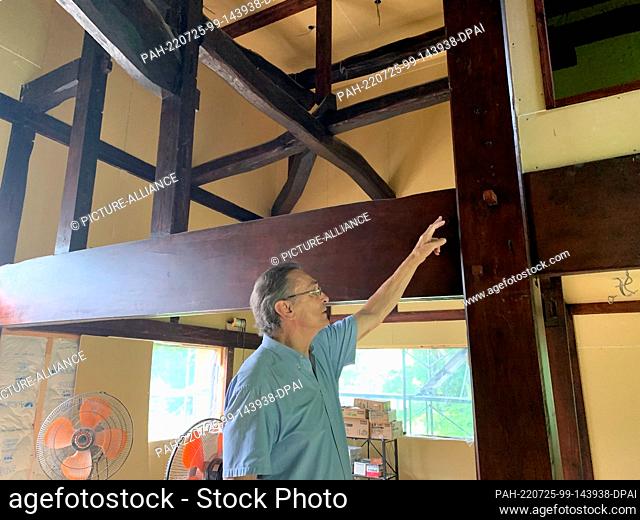 PRODUCTION - 17 July 2022, Japan, Matsudai: German architect Karl Bengs stands next to support beams from an old country house
