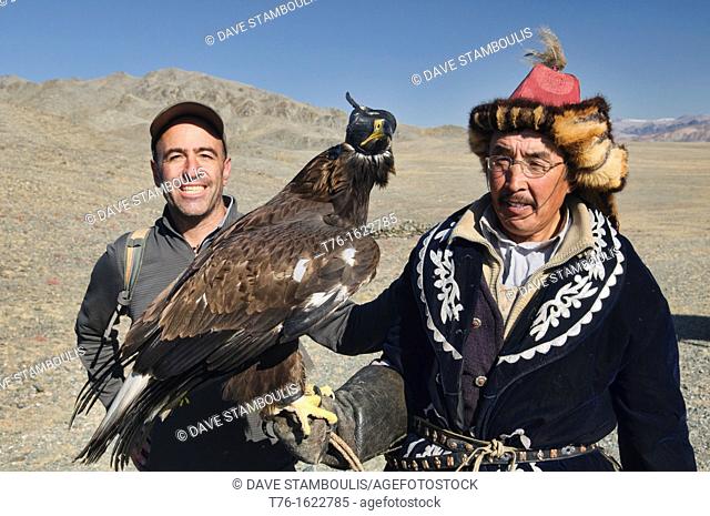 tourist with a Kazakh eagle hunter and his golden eagle in the Altai Region of Bayan-Ölgii in Western Mongolia