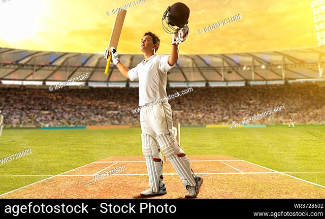 Cricketer celebrating at the pitch with his arms raised