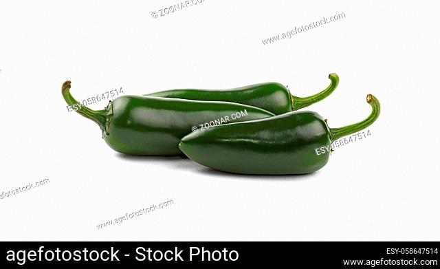 Close up one group of three fresh green jalapeno hot chili peppers isolated on white background, low angle side view